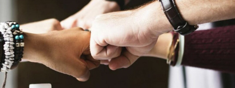 Several hands fist bumping